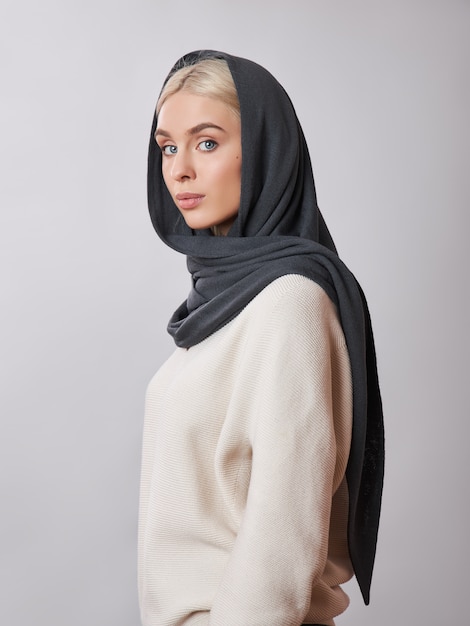 Mulher muçulmana europeia, com um cabelo loiro em um xale de lenço na cabeça.