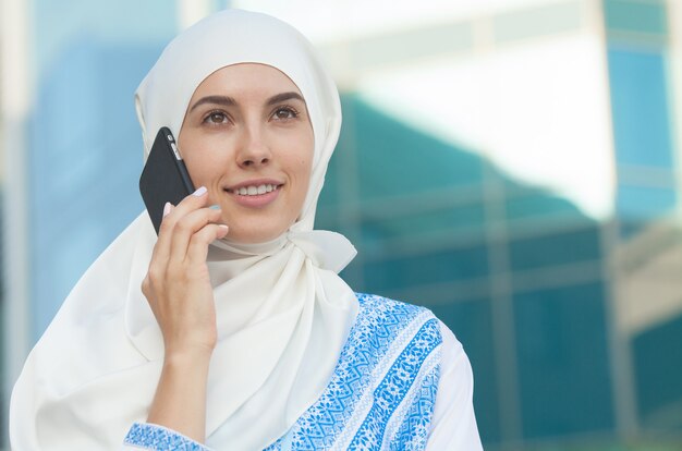 Mulher muçulmana falando ao telefone