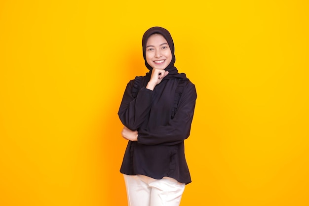 Mulher muçulmana indonésia com uma pose elegante acompanhada por um fundo amarelo