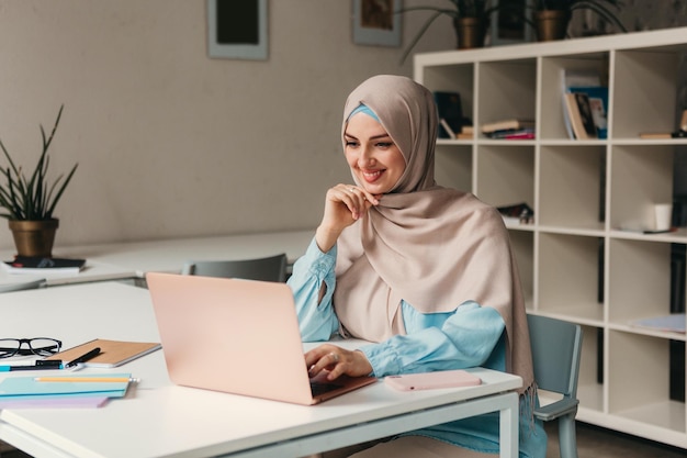 Mulher muçulmana moderna em hijab na sala de escritório