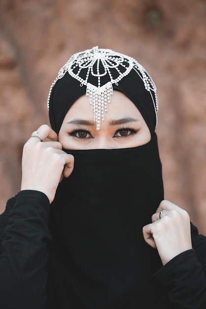 Mulher muçulmana posar no deserto closeup