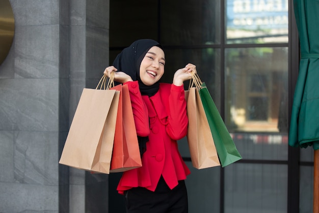 mulher muçulmana segurando sacola de compras