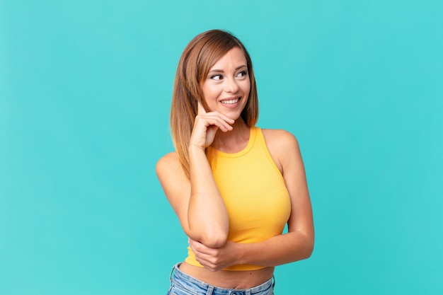 Mulher muito adulta sorrindo com uma expressão feliz e confiante com a mão no queixo