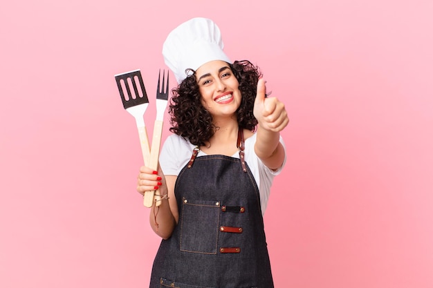 Mulher muito árabe, sentindo-se orgulhosa, sorrindo positivamente com o polegar para cima. conceito de chef churrasco