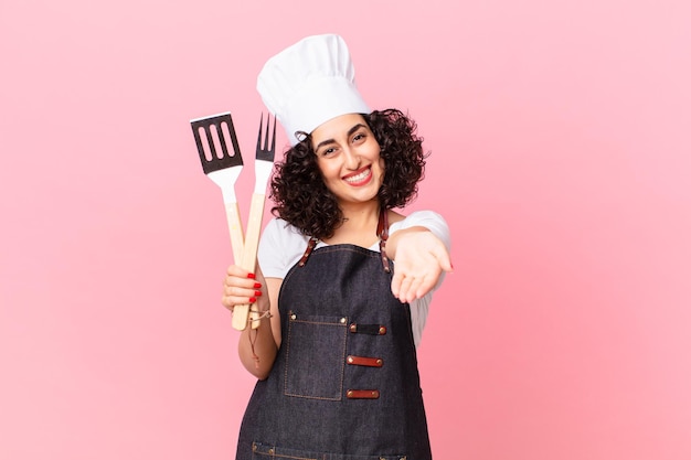 Mulher muito árabe sorrindo alegremente com simpáticos e oferecendo e mostrando um conceito. conceito de chef churrasco