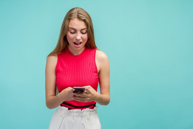 Mulher muito feliz e animada feliz em receber mensagem de texto informando sobre salário se alegra com boas notícias olha para gestos de telefone celular ativamente de felicidade fica sozinho em casa Conceito de reação