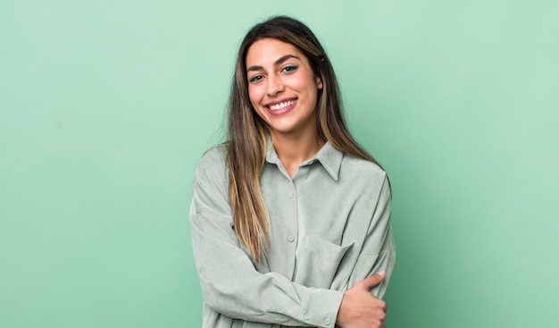 Mulher muito hispânica rindo timidamente e alegremente com uma atitude amigável e positiva, mas insegura