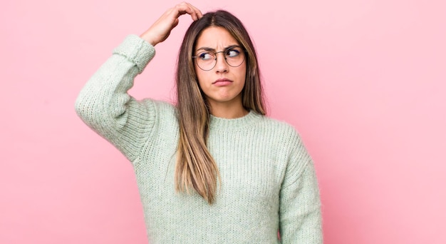 Mulher muito hispânica se sentindo confusa e confusa coçando a cabeça e olhando para o lado