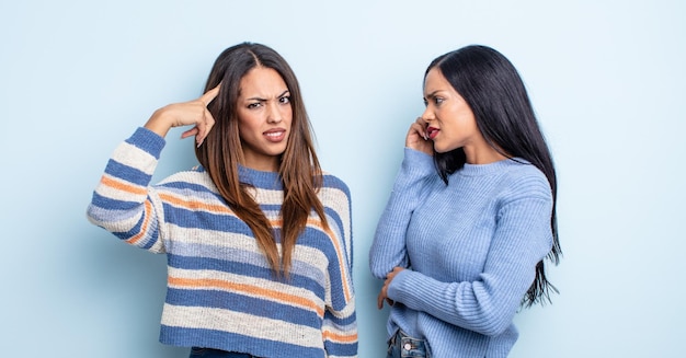 Mulher muito hispânica se sentindo confusa e confusa, mostrando que você é louco. conceito de casal de amigos