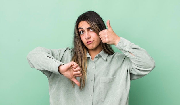 Mulher muito hispânica se sentindo confusa, sem noção e insegura, ponderando o bom e o ruim em diferentes opções ou escolhas