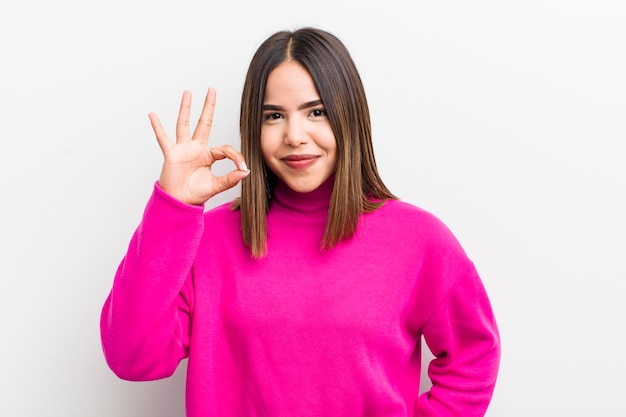 Mulher muito hispânica se sentindo feliz relaxada e satisfeita mostrando aprovação com gesto bem sorrindo