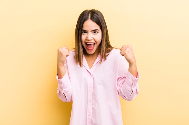 Mulher muito hispânica se sentindo feliz surpresa e orgulhosa gritando e comemorando o sucesso com um grande sorriso