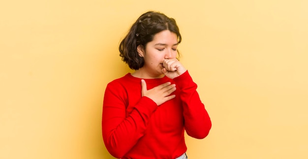 Mulher muito hispânica se sentindo mal com dor de garganta e sintomas de gripe tossindo com a boca coberta