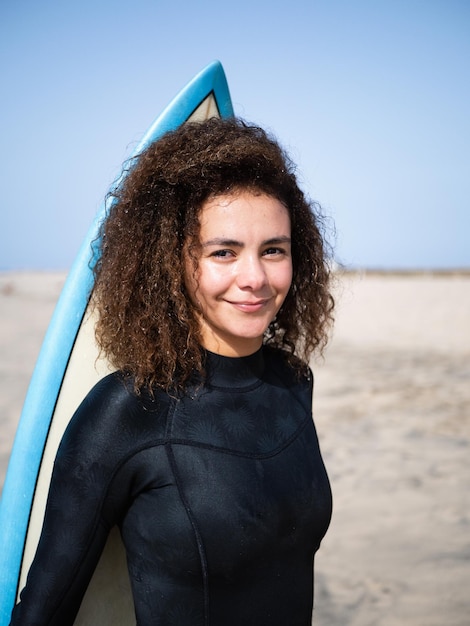 Mulher muito jovem surfista com retrato de cabelo afro