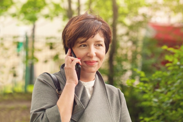 Mulher muito madura telefone retrato ao ar livre