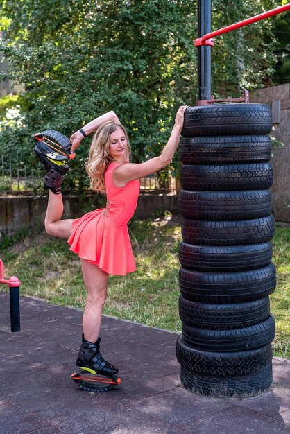 Mulher muito magra em saltos kangoo fazendo exercícios em simuladores de rua