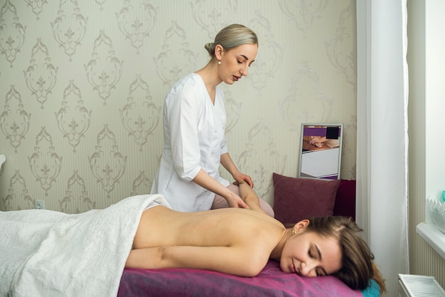 Mulher muito magra, recebendo um tratamento de massagem de saúde em um centro de spa