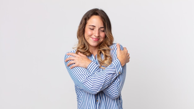 Mulher muito magra se sentindo apaixonada, sorrindo, abraçando e abraçando a si mesma, ficando solteira, sendo egoísta e egocêntrica