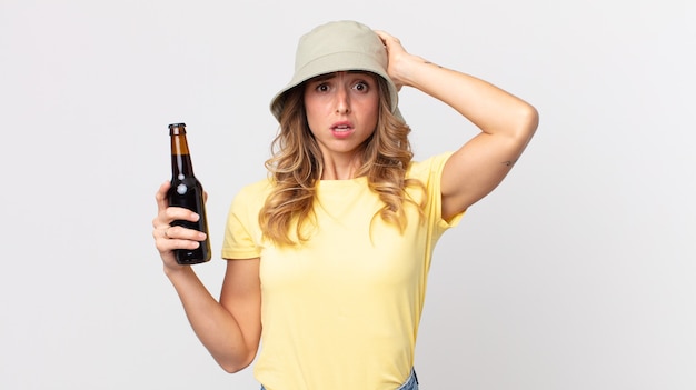 Mulher muito magra se sentindo estressada, ansiosa ou com medo, com as mãos na cabeça e segurando uma cerveja. conceito de verão