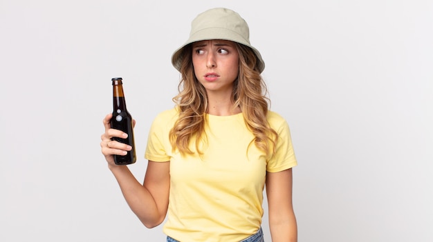 Mulher muito magra se sentindo triste, chateada ou com raiva e olhando para o lado e segurando uma cerveja. conceito de verão