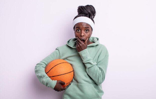 Mulher muito negra com boca e olhos bem abertos e mão no conceito de basquete queixo