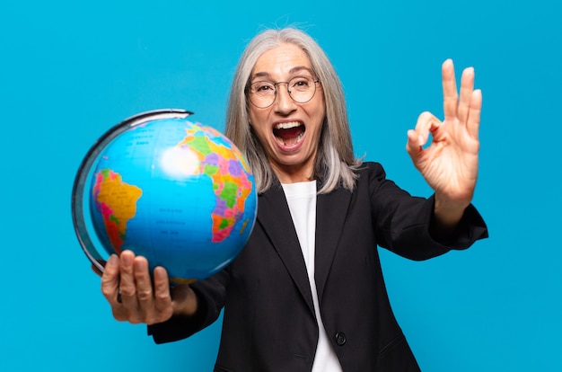 Foto mulher muito sênior com um globo terrestre. conceito de mundo