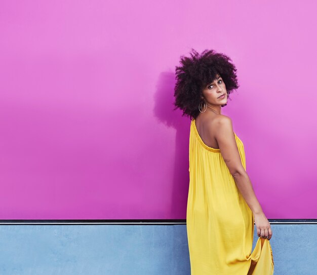 Mulher mulata com cabelo afro com vestido amarelo