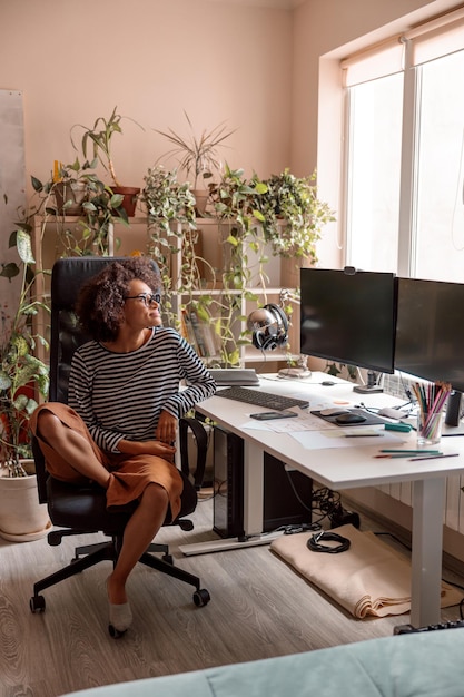 Foto mulher multiétnica sentada à mesa de trabalho em casa