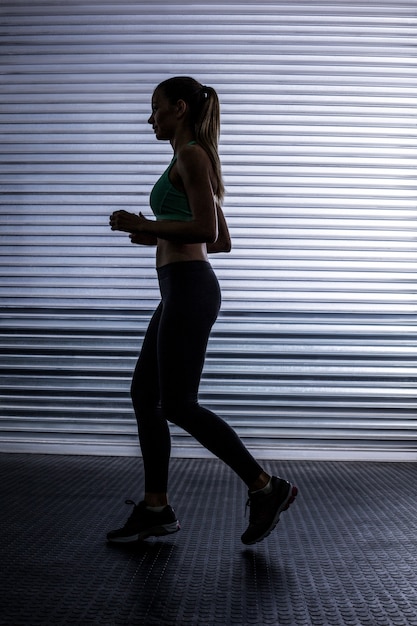 Mulher muscular correndo na sala de ginástica