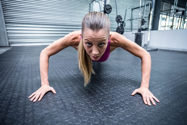 Mulher muscular fazendo flexões