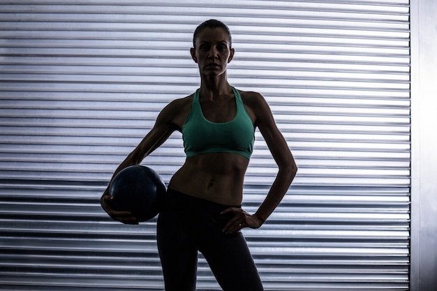 Mulher muscular segurando uma bola de medicina