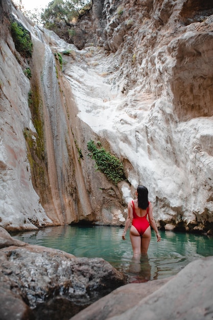 Mulher na cachoeira de Dimosari de maiô vermelho na ilha Grécia de Lefkada