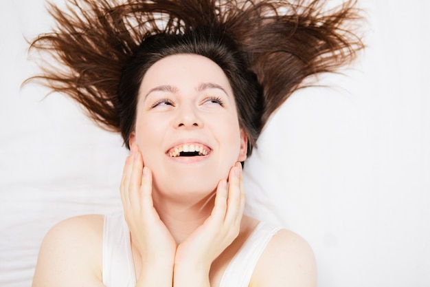 mulher na cama em um lençol branco com emoções diferentes