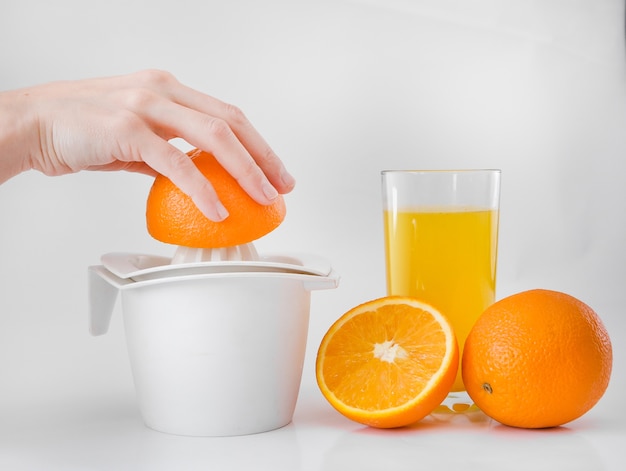 Mulher na cozinha espreme suco laranja