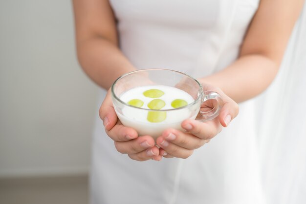 Mulher na dieta saudável. close de uma linda garota alegre com um copo de iogurte natural