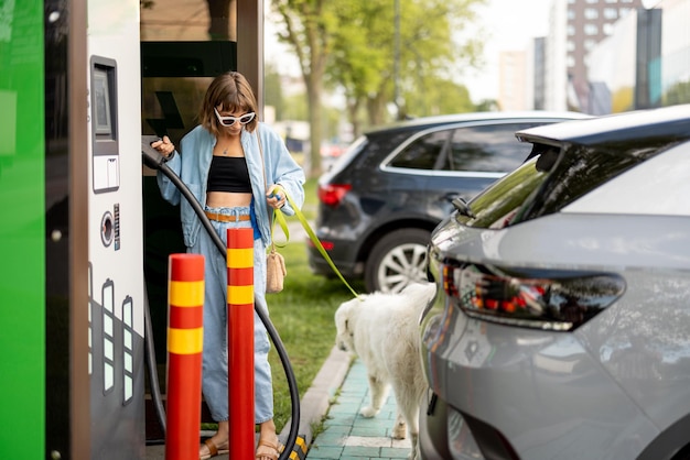 Mulher na estação de carregamento de carros elétricos