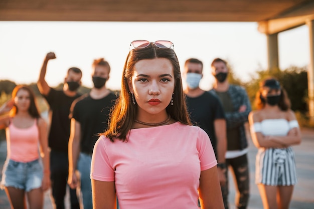 Foto mulher na frente da multidão grupo de jovens protestando que estão juntos ativista pelos direitos humanos ou contra o governo