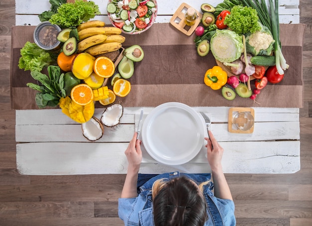 Foto mulher na mesa de jantar com alimentos orgânicos