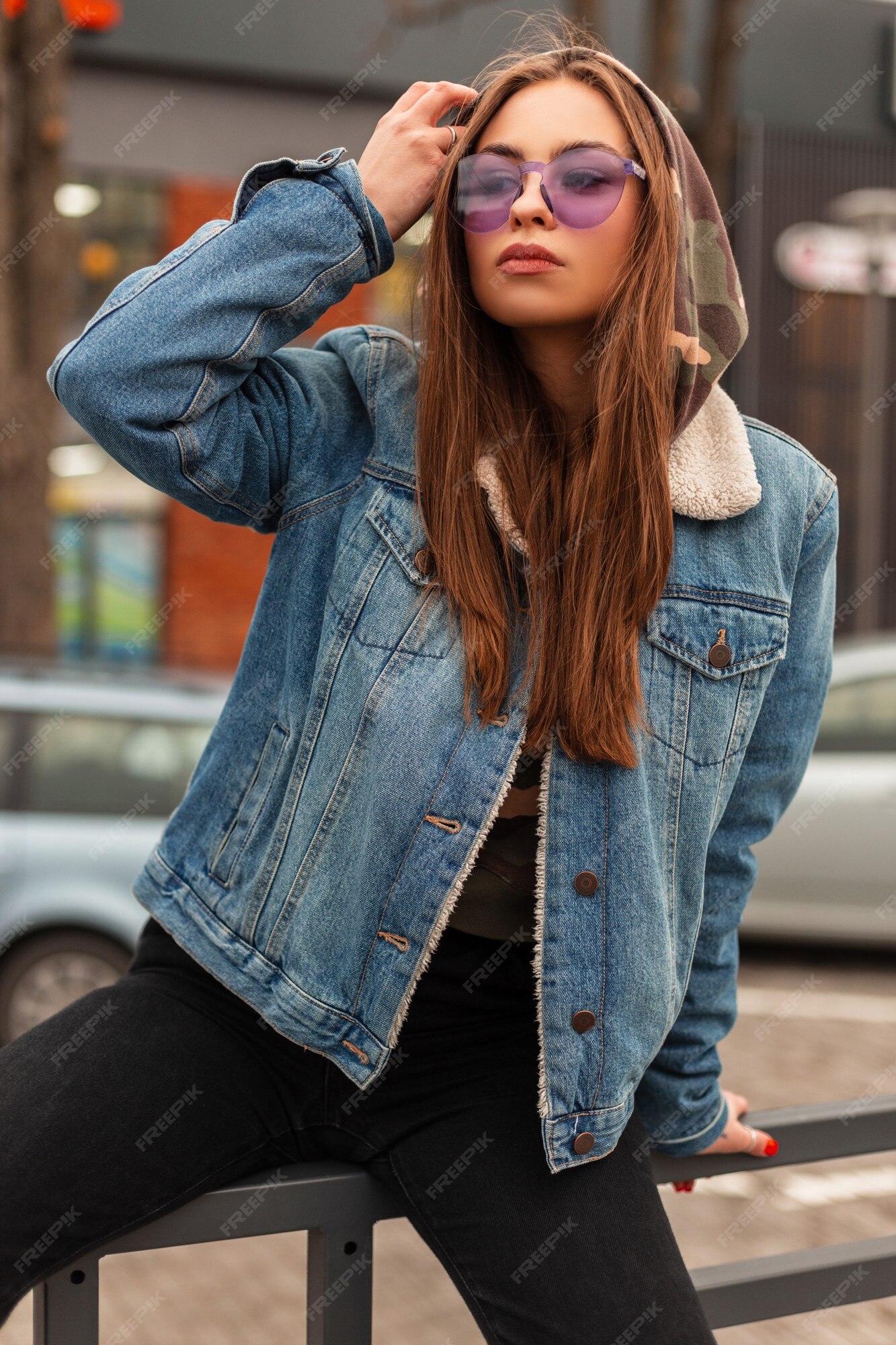 Mulher bonita e jovem hippie em uma jaqueta jeans da moda com uma