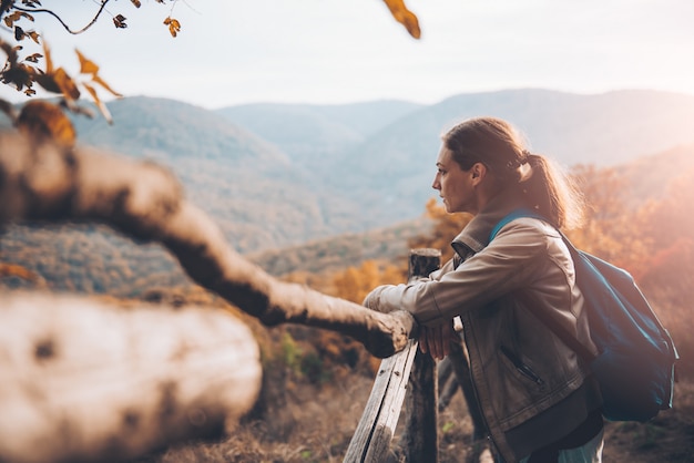 Foto mulher na montanha em pé ao lado da cerca e apreciando a vista