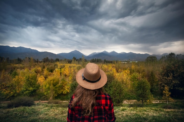 Mulher na paisagem de montanhas de outono