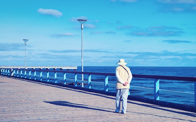 Mulher na ponte do mar sobre o mar Báltico no resort Palanga, Lituânia