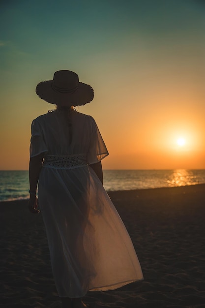 Mulher na praia ao pôr do sol. Foco seletivo.