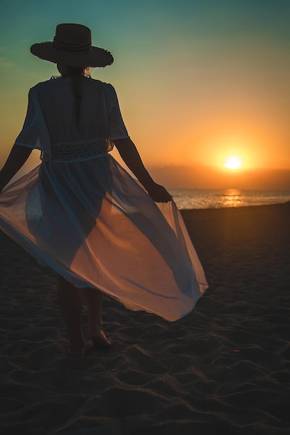 Mulher na praia ao pôr do sol. Foco seletivo.