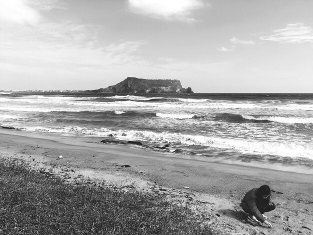 Mulher na praia contra o céu