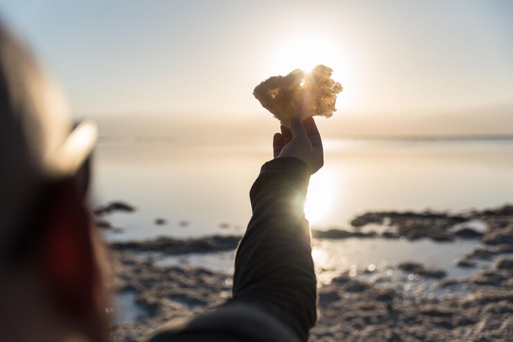 Foto mulher na praia contra o mar durante o pôr-do-sol