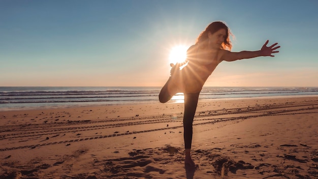 Mulher na praia em posição de ioga