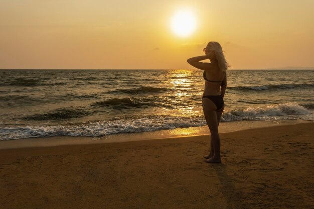 Foto mulher na praia tropical ao pôr do sol praia tropical durante o pôr-do-sol em pattaya, tailândia
