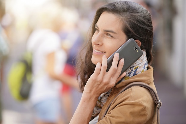 Mulher na rua falando no telefone