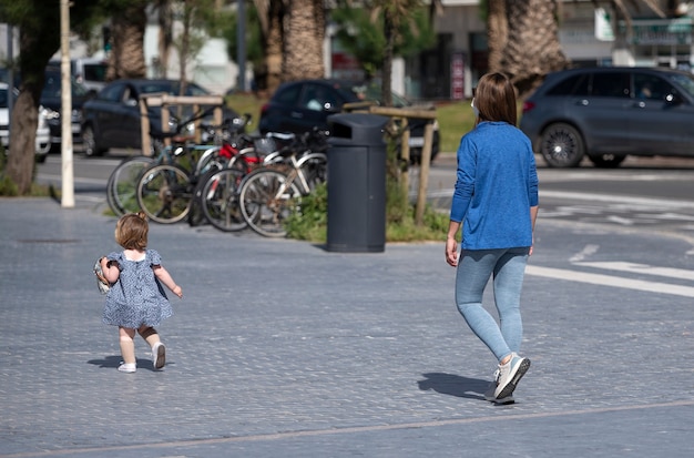 Mulher na rua passeando com sua filha